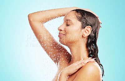 Buy stock photo Shot of an attractive young woman showering against a blue background