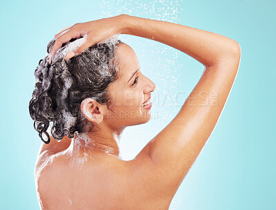 Buy stock photo Shot of an young woman enjoying a soapy shower against a blue background