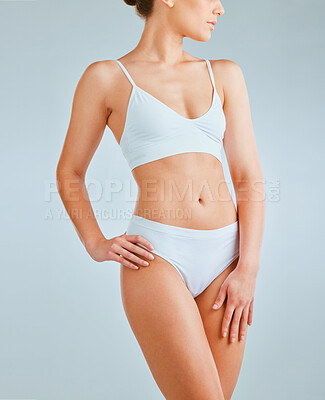 Buy stock photo Cropped shot of a young woman wearing underwear while posing against a grey background
