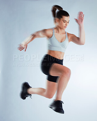 Buy stock photo Woman, fitness and jump with athlete in air for speed, training or agility on a gray studio background. Active female person with motion blur in cardio or athletics for running, endurance or stamina