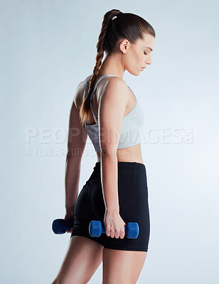 Buy stock photo Woman, fitness and weightlifting with dumbbells for strength or empowerment on a gray studio background. Young, active female person or athlete with small weight in confidence for strong endurance