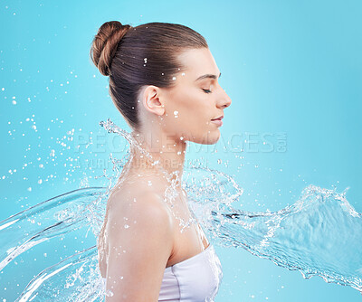 Buy stock photo Calm woman, wash and hydration with water splash for hygiene or hydro skincare in studio on a blue background. Young female person, model or mineral liquid for shower, natural aqua or clean skin