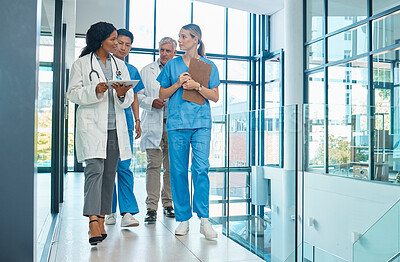 Buy stock photo Hospital, doctors and nurses team walking with a tablet for a discussion, planning or research. Diversity men and women healthcare group talking about medical strategy, virus or surgery schedule
