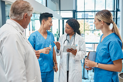Buy stock photo Healthcare, doctors and nurses talking in a hospital with a tablet for research, planning or schedule. Men and women medical group together for communication strategy, virus or surgery in a hospital