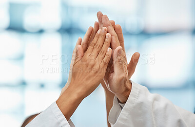 Buy stock photo Shot of a group of unrecognizable doctors putting their hands together at a hospital