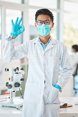 Buy stock photo Portrait of a young scientist gesturing an okay sign in a lab