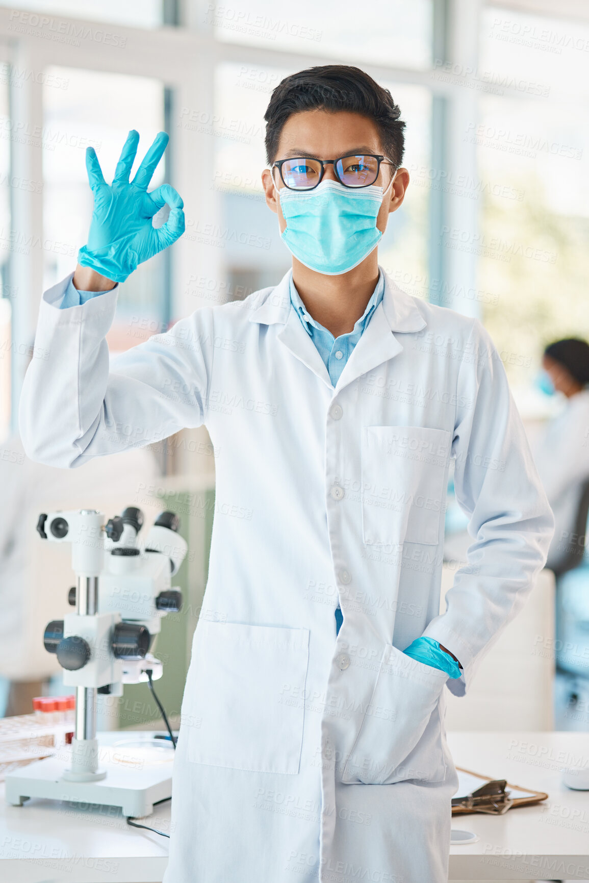 Buy stock photo Portrait of a young scientist gesturing an okay sign in a lab