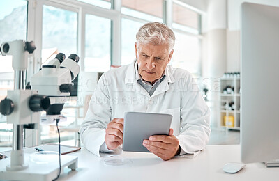 Buy stock photo Shot of a senior scientist using a digital tablet in a lab