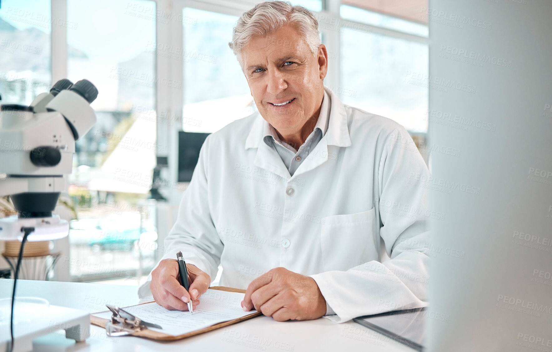 Buy stock photo Portrait of a senior scientist writing notes while using a microscope in a lab