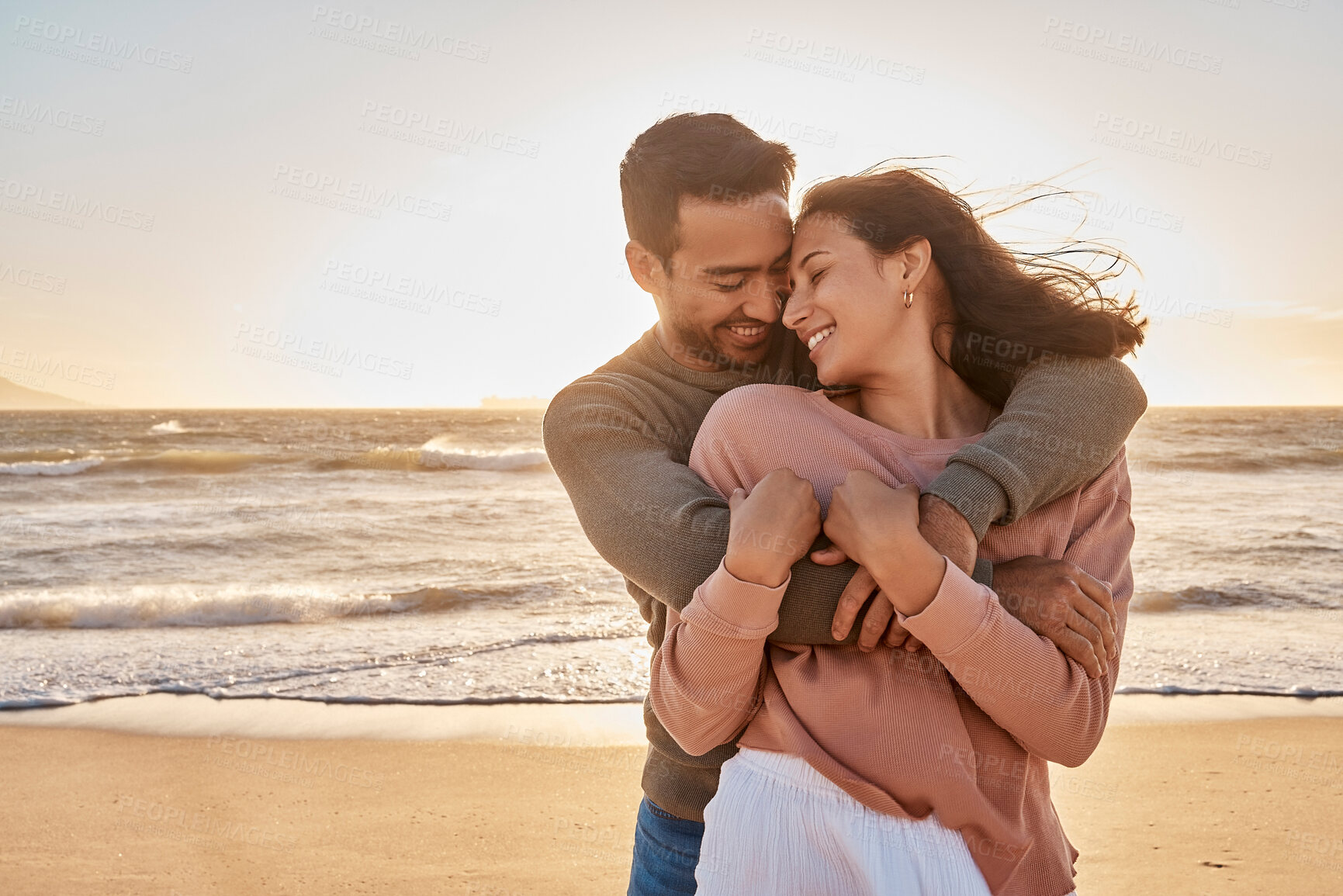 Buy stock photo Love, sunset and couple with hug by coast for affection, relationship or weekend getaway. Beach, hispanic man and happy woman with embrace for vacation, anniversary or romantic date in Zanzibar