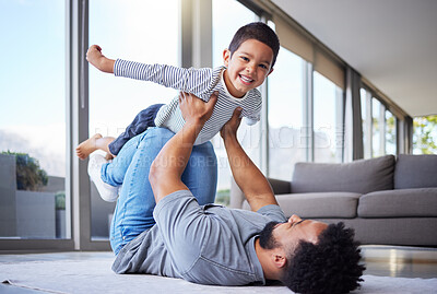 Buy stock photo Shot of a young father playing with his son at home
