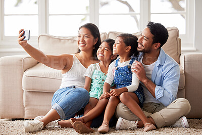 Buy stock photo Happy young family taking a family selfie while relaxing and spending family time together at home