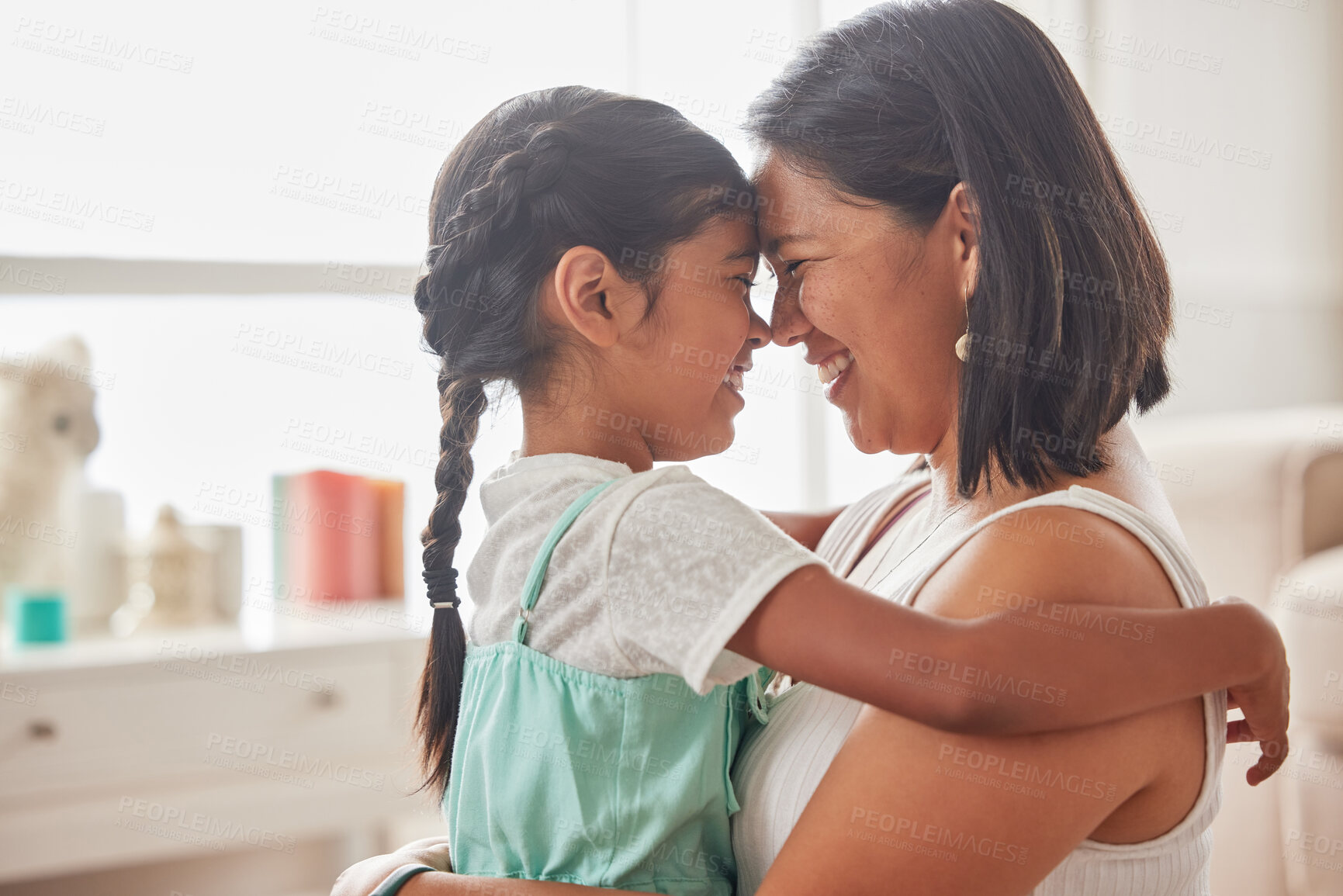 Buy stock photo Woman, kid and smile with hug in home for support, affection and connection in childhood. Happy Indonesian family, mom and little girl with embrace in living room for love, trust and motherhood