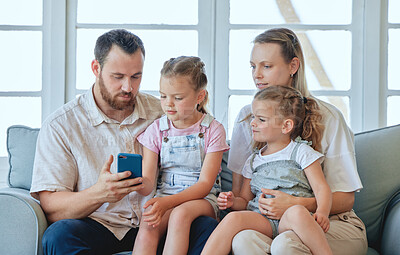 Buy stock photo Shot of a young family using a phone together at home
