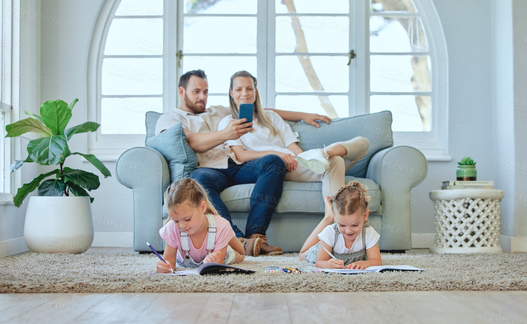 Buy stock photo Shot of a young family relaxing at home