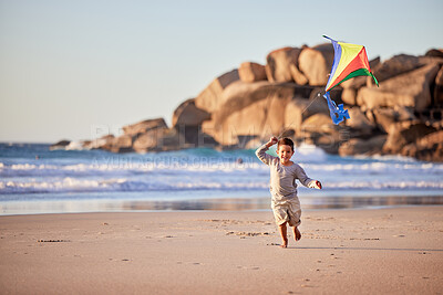 Buy stock photo Shot of a little boy playing with his kite on the beach