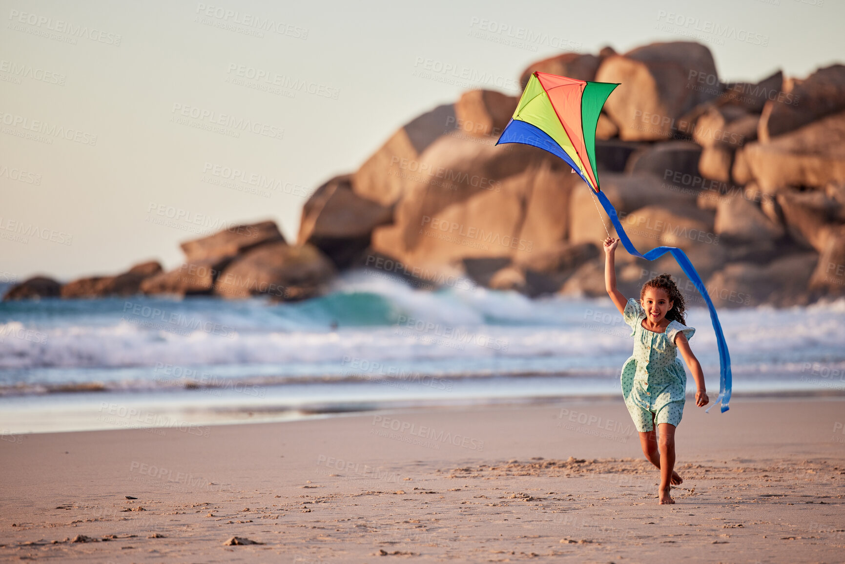 Buy stock photo Shot of a little girl playing with her kite on the beach