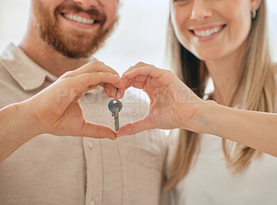 Buy stock photo Shot of an unrecognizable couple making a heart gesture with their hands while holding the keys to their new house