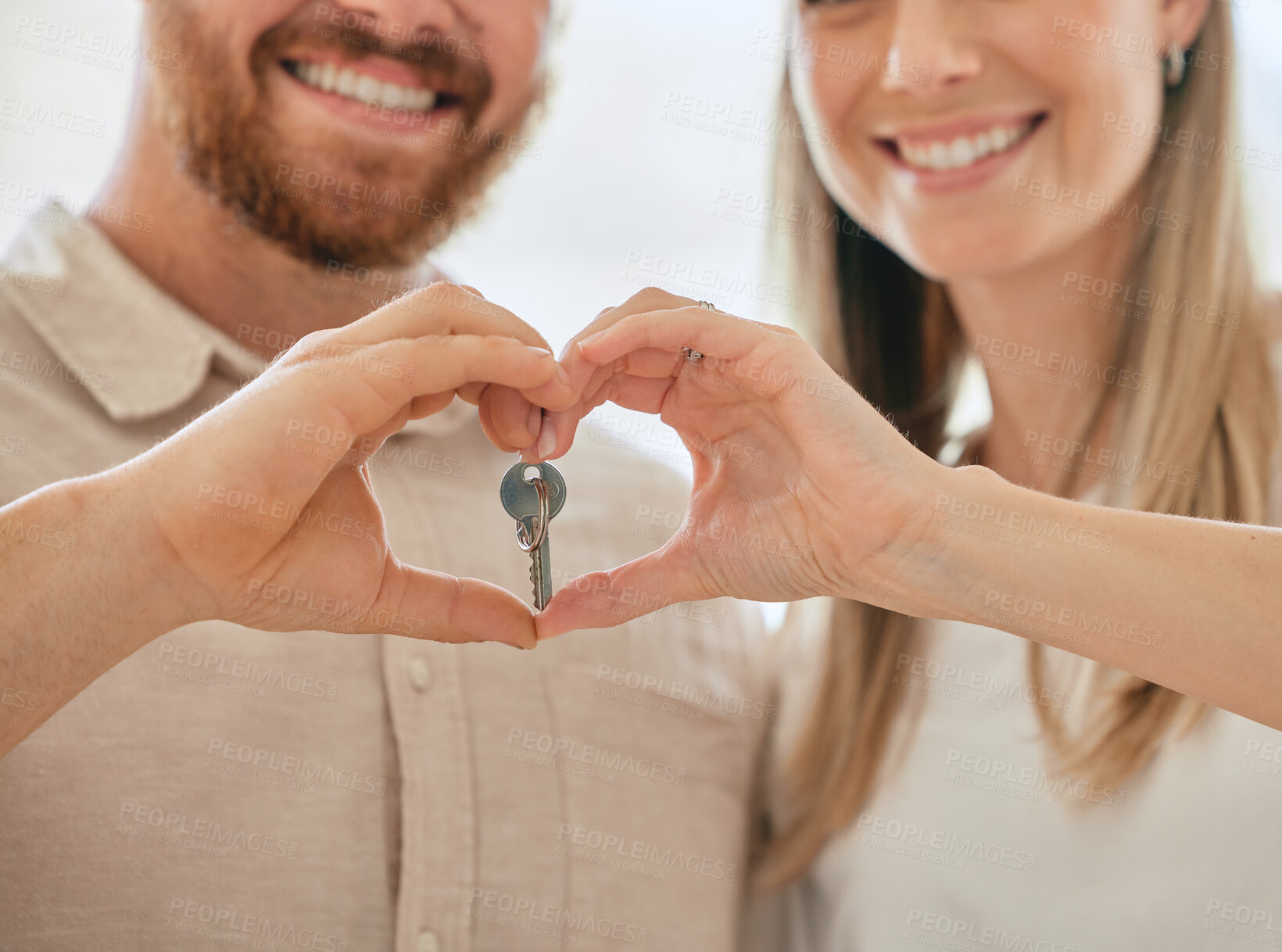 Buy stock photo Shot of an unrecognizable couple making a heart gesture with their hands while holding the keys to their new house