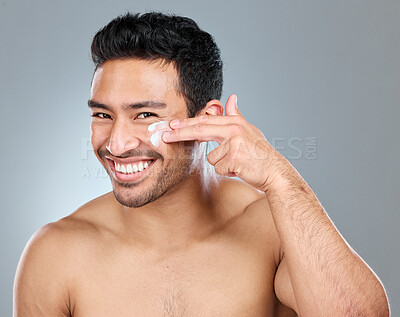 Buy stock photo Man, smile and portrait with face cream in studio for skincare, hydration and skin tone with dermatology or cosmetology. Person, lotion and product on gray background for facial care, shine and glow.