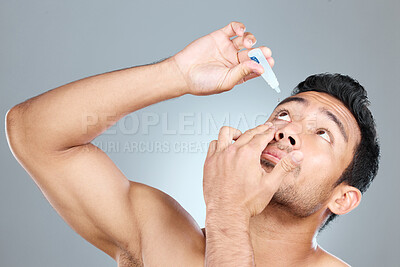 Buy stock photo Model, eye drops and vision in studio for healthcare, eyesight and medical product for allergies. Shirtless man, liquid solution and eyes to stop allergy, self care and wellness on gray background