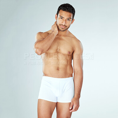 Buy stock photo Shot of a muscular young man posing against a studio background