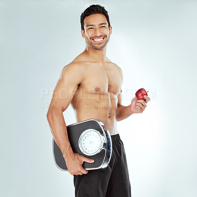 Buy stock photo Scale, health and portrait of fitness man with apple in studio for Weight loss, diet or detox on white background. Nutrition, balance or face of wellness model smile for superfoods, fruit or progress