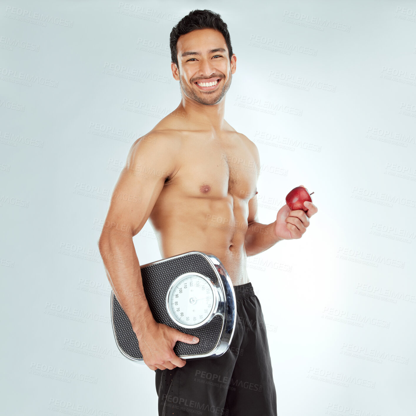 Buy stock photo Scale, health and portrait of fitness man with apple in studio for Weight loss, diet or detox on white background. Nutrition, balance or face of wellness model smile for superfoods, fruit or progress