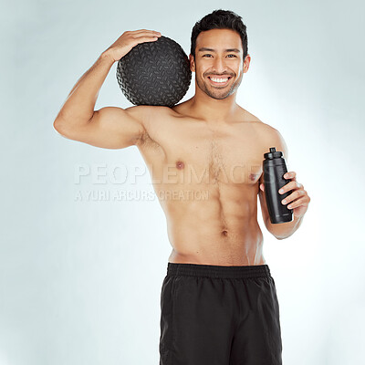 Buy stock photo Fitness, water and portrait of happy man with medicine ball in studio for wellness, training and hydration on white background. Face, smile and male athlete with workout, results or body progress