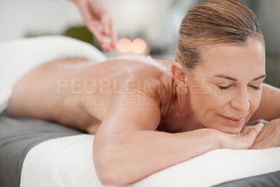 Buy stock photo Shot of a masseuse pouring exfoliating salt scrub onto a clients back