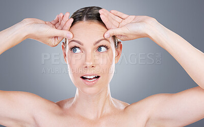 Buy stock photo Studio shot of an attractive mature woman touching her forehead against a grey background