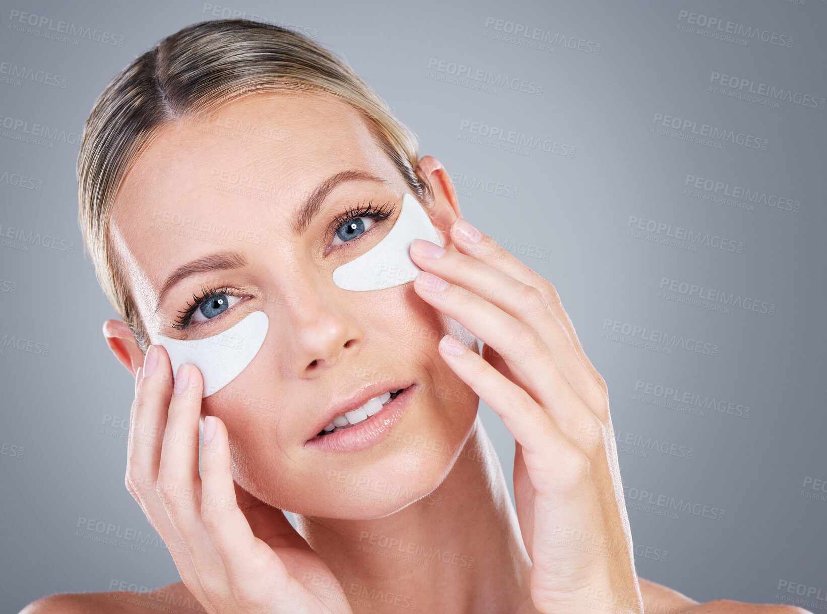 Buy stock photo Studio portrait of an attractive mature woman wearing under eye patches against a grey background