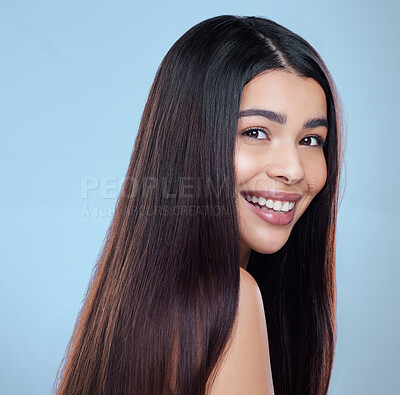 Buy stock photo Studio portrait of a beautiful young woman showing off her long silky hair against a blue background