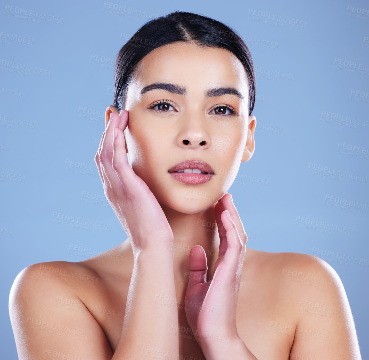 Buy stock photo Shot of an attractive young woman posing alone against a blue background in the studio