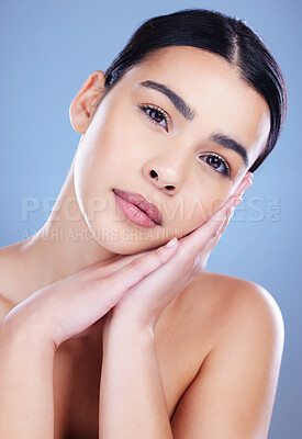 Buy stock photo Shot of an attractive young woman posing alone against a blue background in the studio