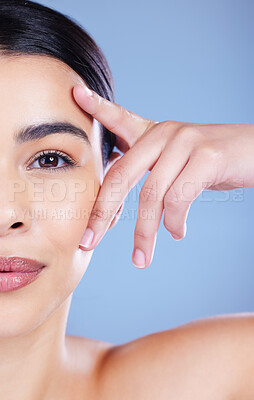 Buy stock photo Cropped shot of a young woman posing alone against a blue background in the studio