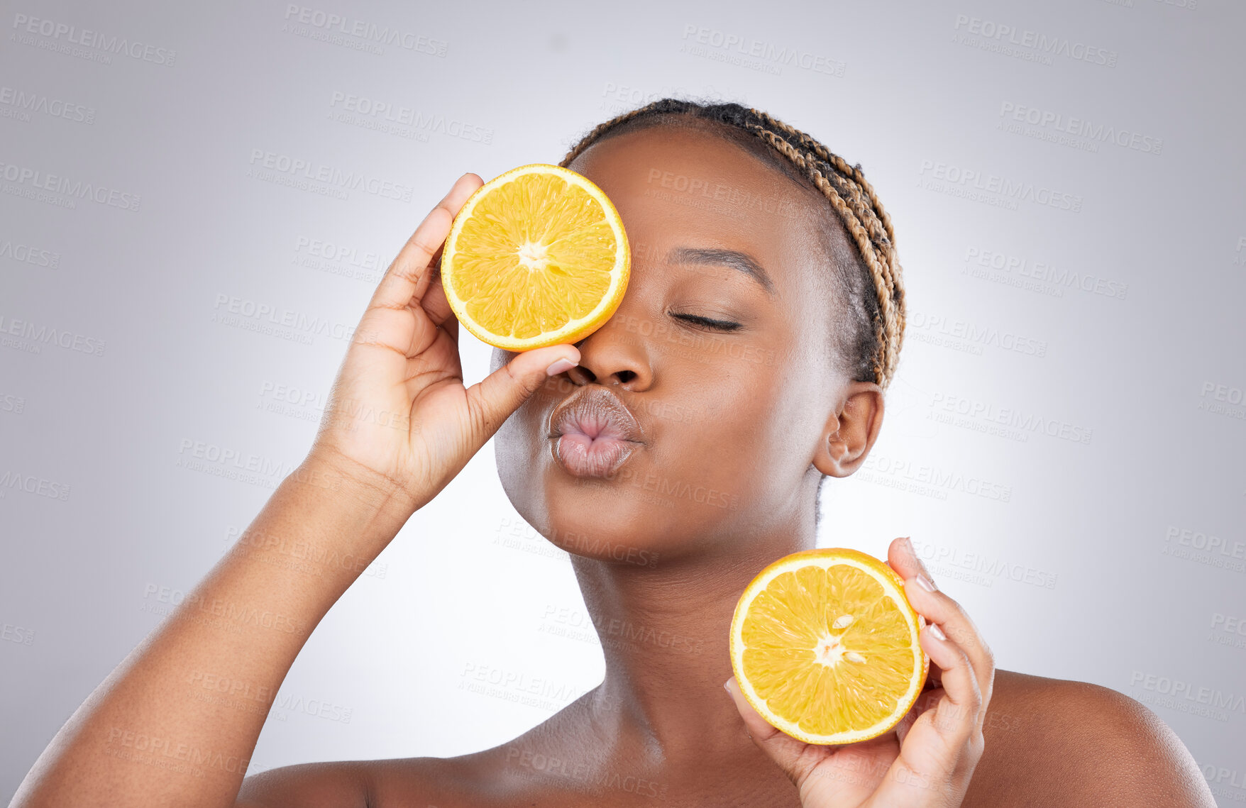 Buy stock photo Beauty, orange and kiss with black woman in studio for natural, cosmetics and vitamin c. Nutrition, diet and detox with face of female model on grey background for citrus fruit and health product