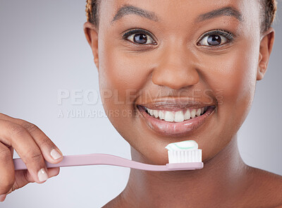 Buy stock photo African woman, brushing teeth and studio portrait with smile for oral wellness by white background. Girl, model and person with plastic toothbrush with toothpaste, health and clean mouth for change