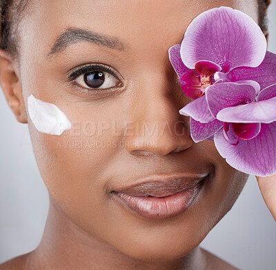 Buy stock photo Face, black woman and beauty with flower, cream and skincare on studio background. Orchid, clean and closeup for vegan lotion for female person, eco or plant based for organic cosmetic and body care