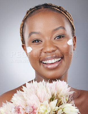 Buy stock photo Woman, portrait and cream with flowers in studio for natural beauty, organic skincare and eco friendly lotion. Model, black person or happy with moisturizer treatment for skin glow on gray background