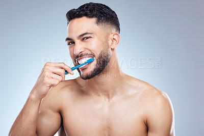 Buy stock photo Man, portrait and smile with brushing teeth in studio for oral hygiene, mouth cleaning and morning routine. Person, toothbrush and fresh breath with dental and healthy gums on gray background