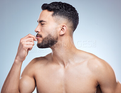 Buy stock photo Nose, grooming and man with tweezers in studio for hair removal, plucking or morning routine on white background. Beauty, body and hand of model with cleaning tool for self care, wellness or salon