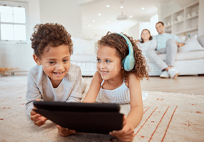 Buy stock photo Shot of a little brother and sister using a digital tablet together at home