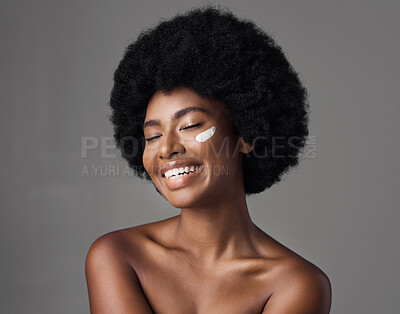 Buy stock photo African woman, beauty cream and studio with afro, skincare and cosmetics by grey background. Girl, happy model and healthy with natural glow on skin with makeup, clean aesthetic and product for face