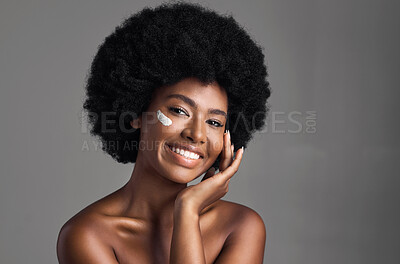 Buy stock photo Black woman, cream on face and beauty with cosmetics product, skincare and dermatology on studio background. Natural, afro hairstyle and African female model smile in portrait, lotion and moisturizer