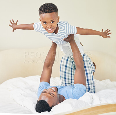 Buy stock photo Shot of a young father lying down and bonding with his son while playing with him at home