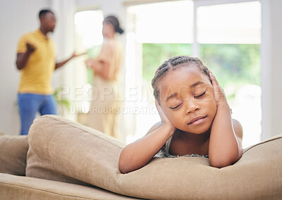 Buy stock photo Shot of an adorable little girl sitting on the sofa and blocking her ears while her parents argue behind her