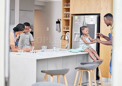 Buy stock photo Shot of a young family bonding in the kitchen at home