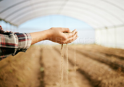 Buy stock photo Shot of a farmer letting dirt pour through her fingers