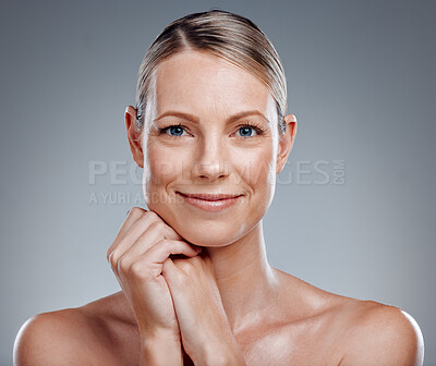 Beautiful mature woman posing in studio against a grey background